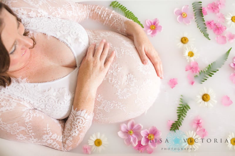 A milk bath photo with a pregnant woman holding her belly